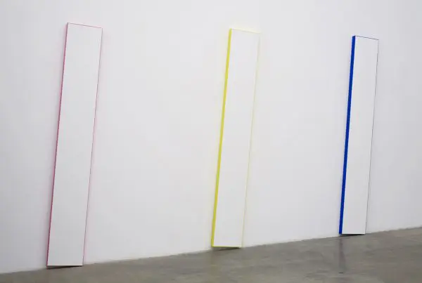 Three painted panels in pink, yellow, and blue.