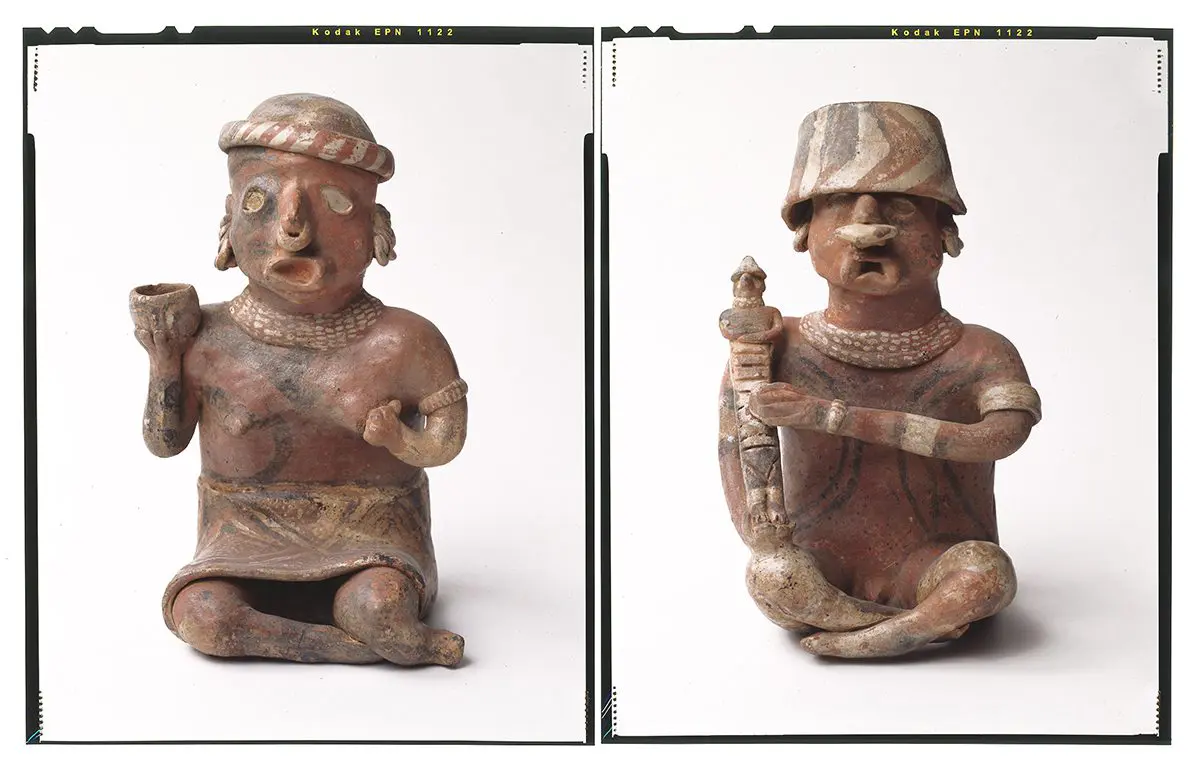 Two ancient clay figures with elaborate headwear.