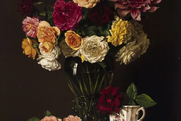 A painting of roses and dahlias in a vase on a red table.
