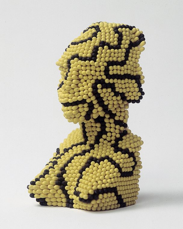 A sculpture of a woman made of yellow and black matchsticks.