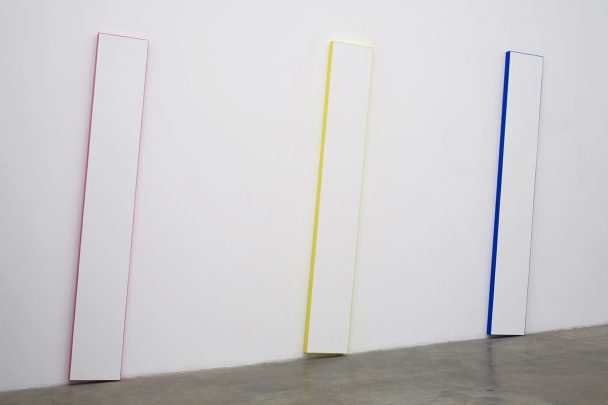 Three painted panels in pink, yellow, and blue.