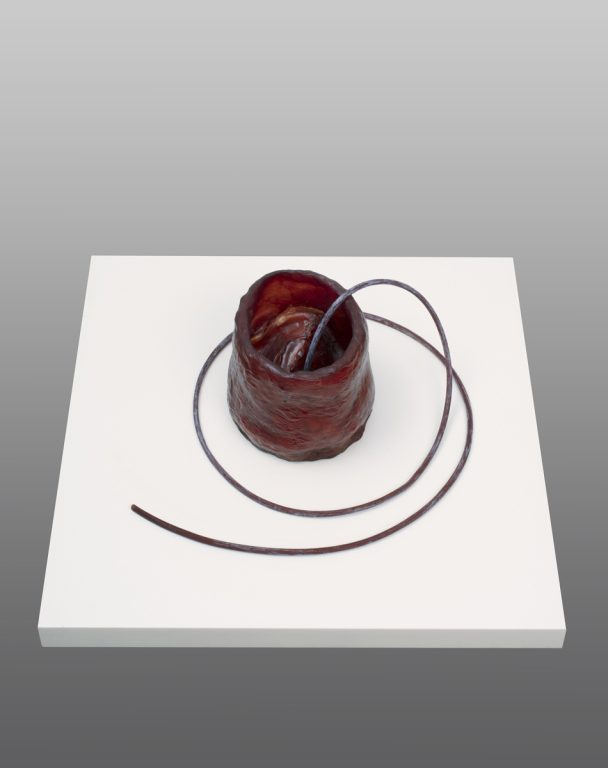 A brown clay sculpture with a wire.