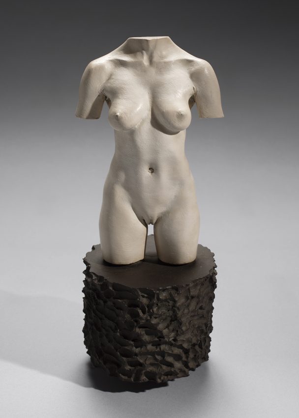 White female torso sculpture on black stand.