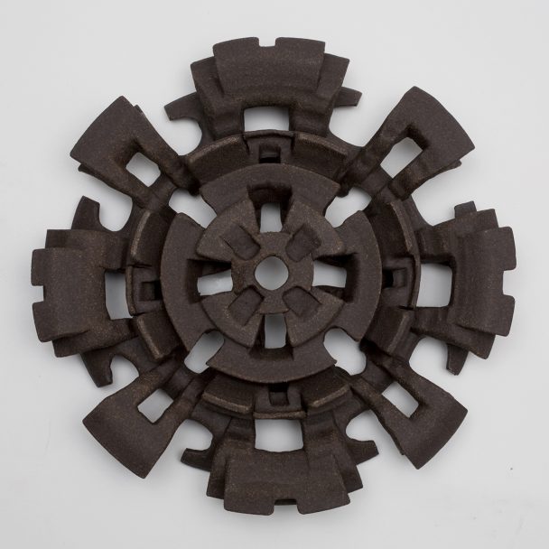 A brown ceramic sculpture resembling a gear.