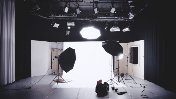 Photo studio with lights and white backdrop.